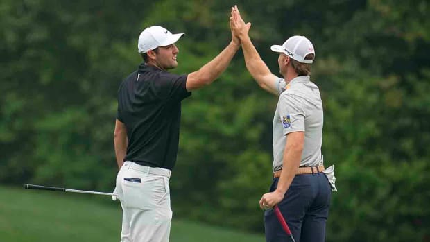 Scottie Scheffler and Sam Burns high-five during a 2023 Masters practice round.